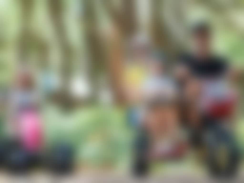 Pedal play family riding pedal carts on bushland path