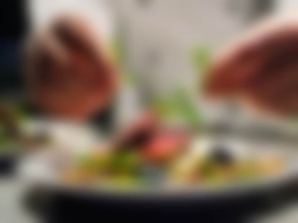 Chef garnishes beef dish